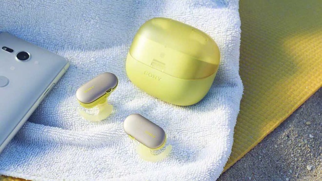 Sony WF-SP900 green ear buds and case charger on towel